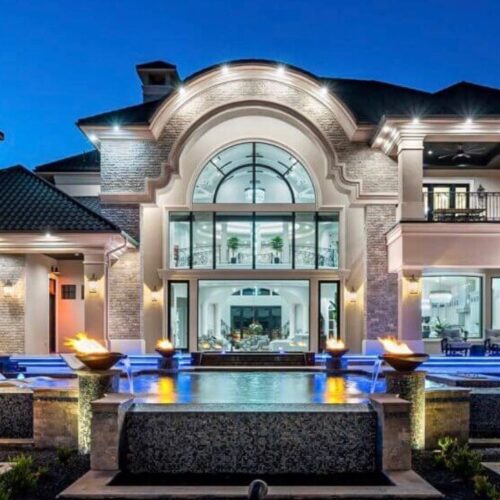 Luxury home with custom grand iron entry door and matching arched window by Ramirez Iron Works