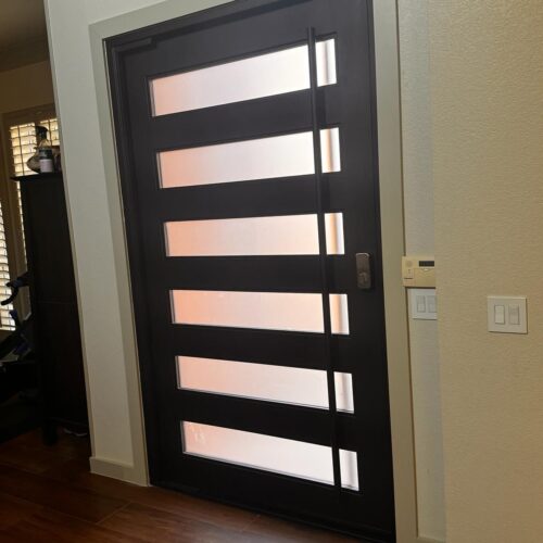 Modern black iron door with horizontal frosted glass panels – interior view