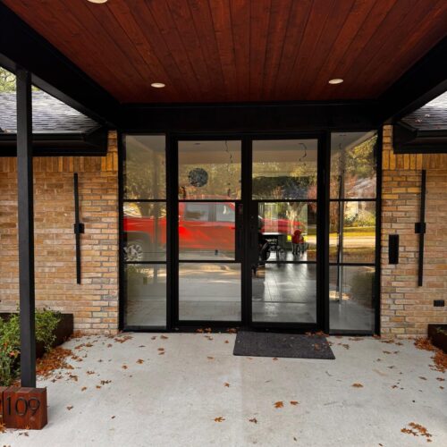 Custom French double iron door with clear glass and sidelights on brick exterior