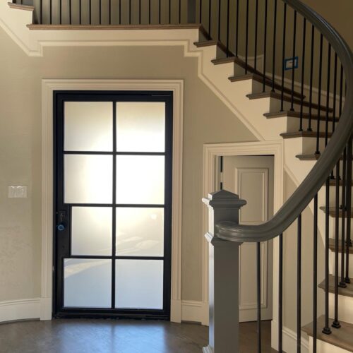 Frosted glass black iron door with square grid design in staircase entryway