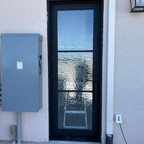 Black iron door with textured privacy glass – exterior view