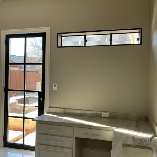 Modern black iron door and horizontal iron window in luxury interior with marble countertop